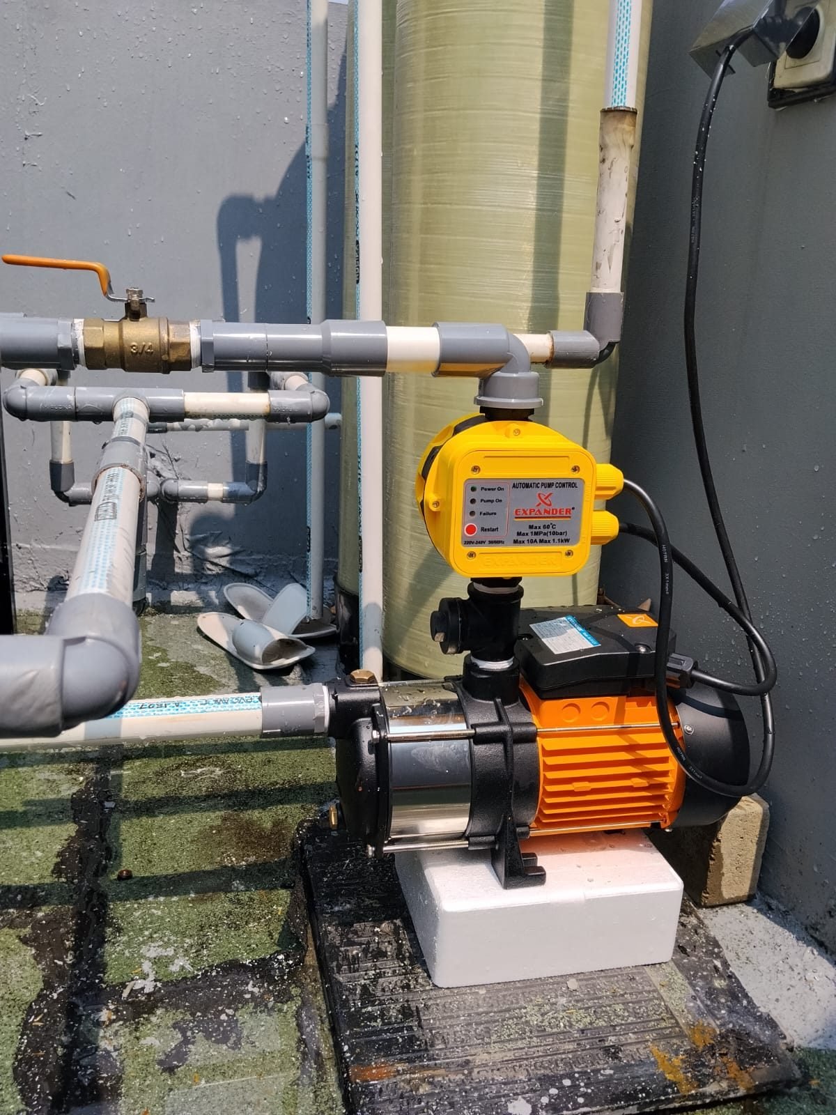 Pemasangan pompa booster stainless dengan automatic pump control di samping tabung filter air
