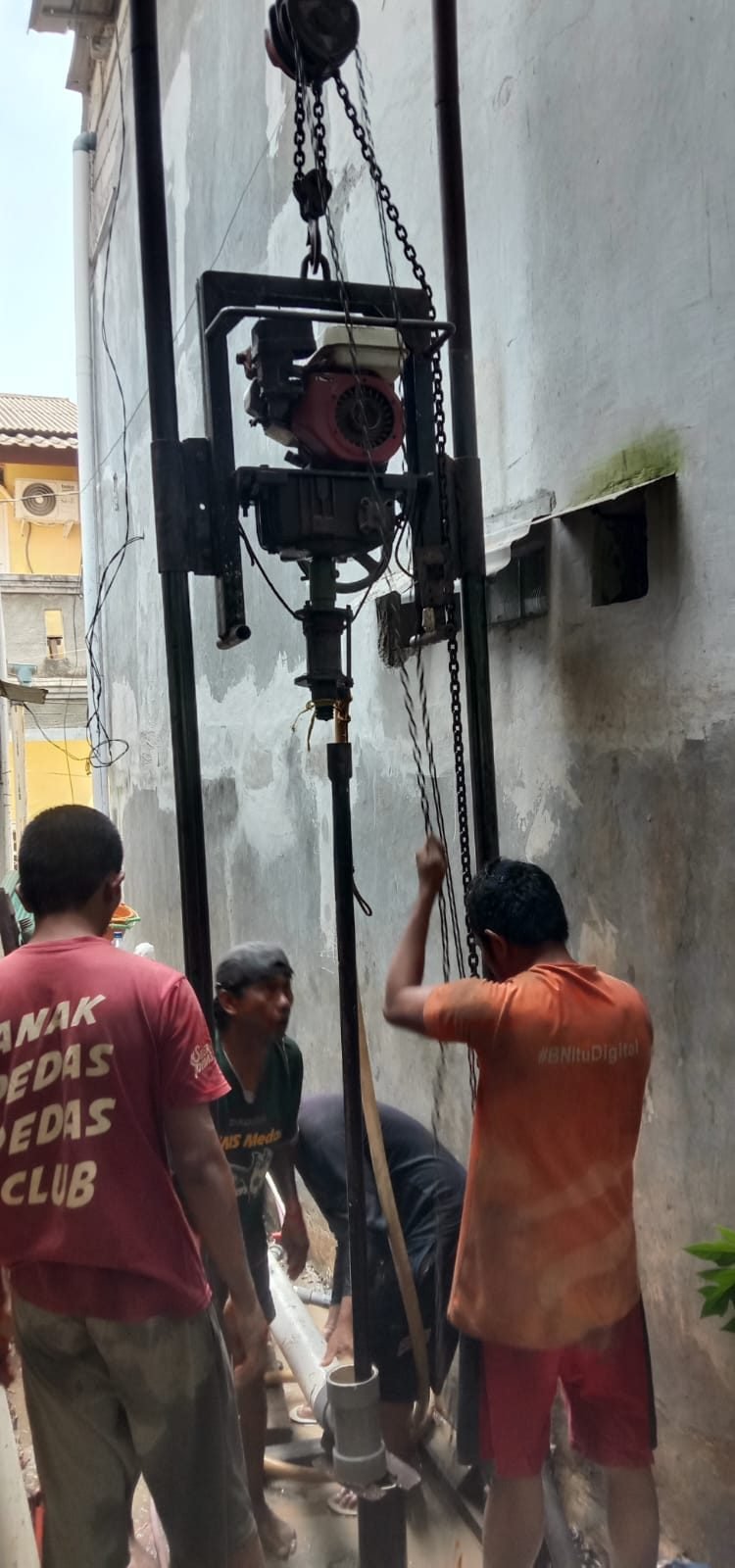 Pengeboran sumur bor di lahan sempit dan gang menggunakan rig bor portabel dengan katrol rantai