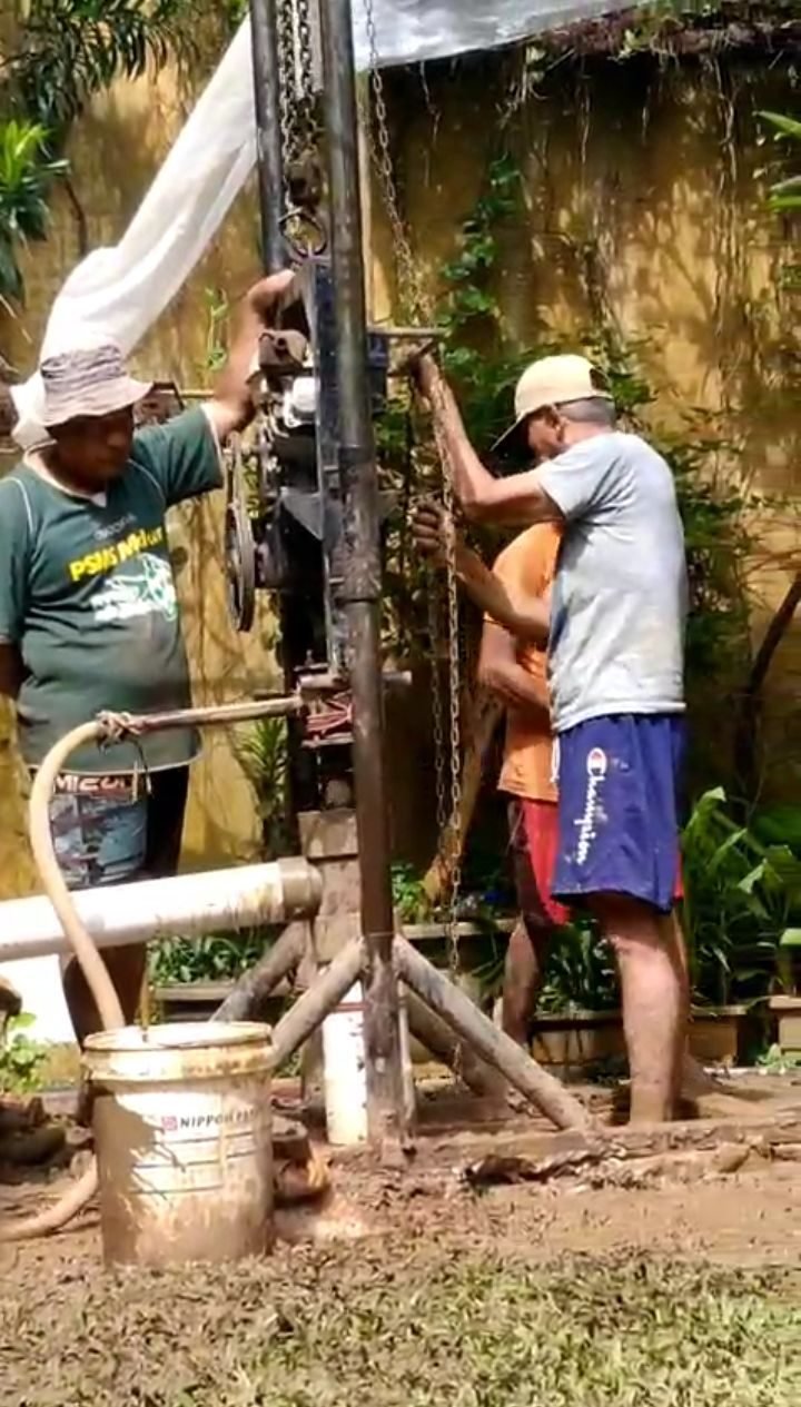 Tim Putra Teknik mengoperasikan mesin bor sumur di halaman rumah pelanggan di Jakarta Selatan