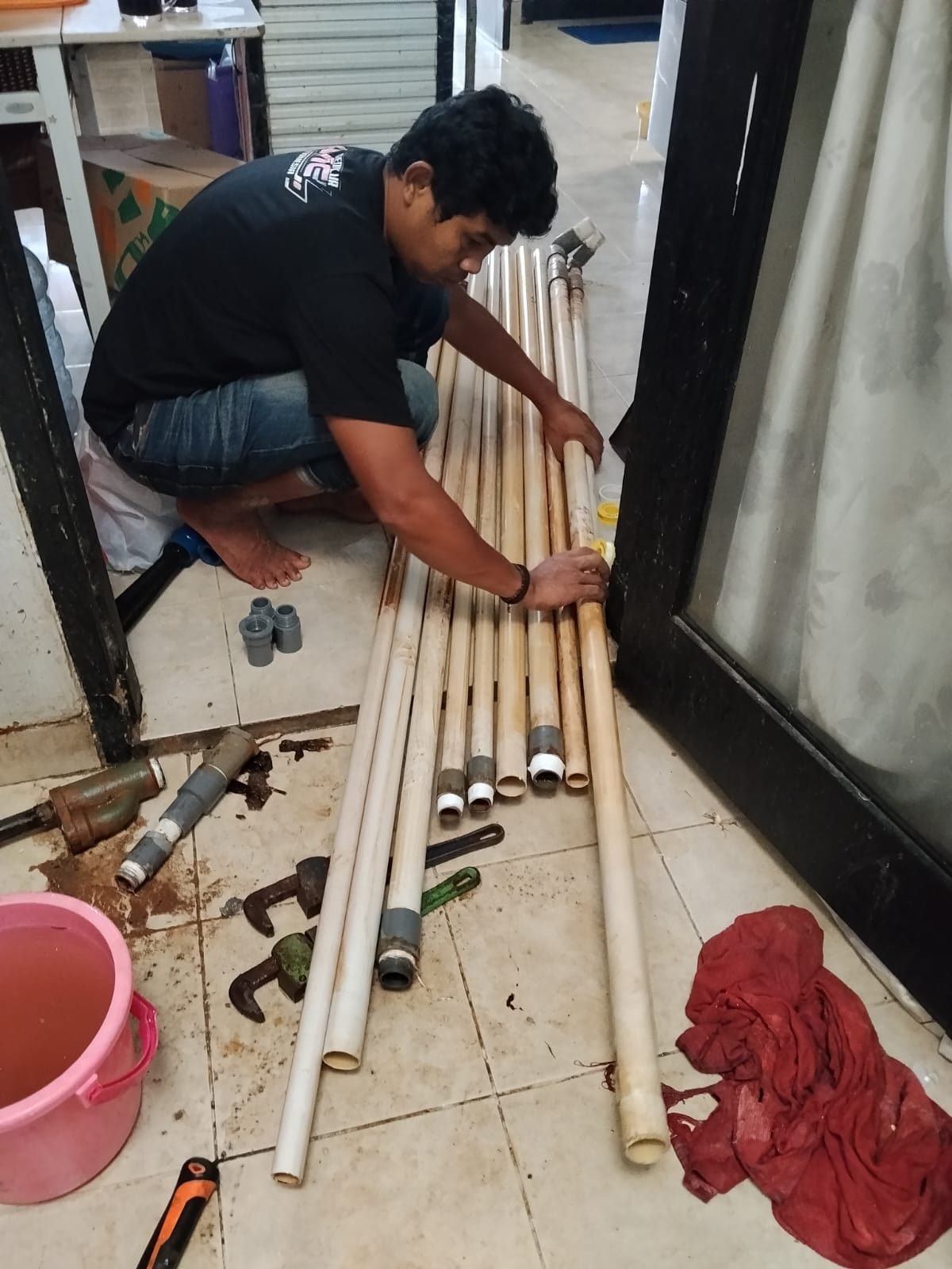 Teknisi Putra Teknik membongkar pipa hisap sumur yang berkarat saat servis pompa air